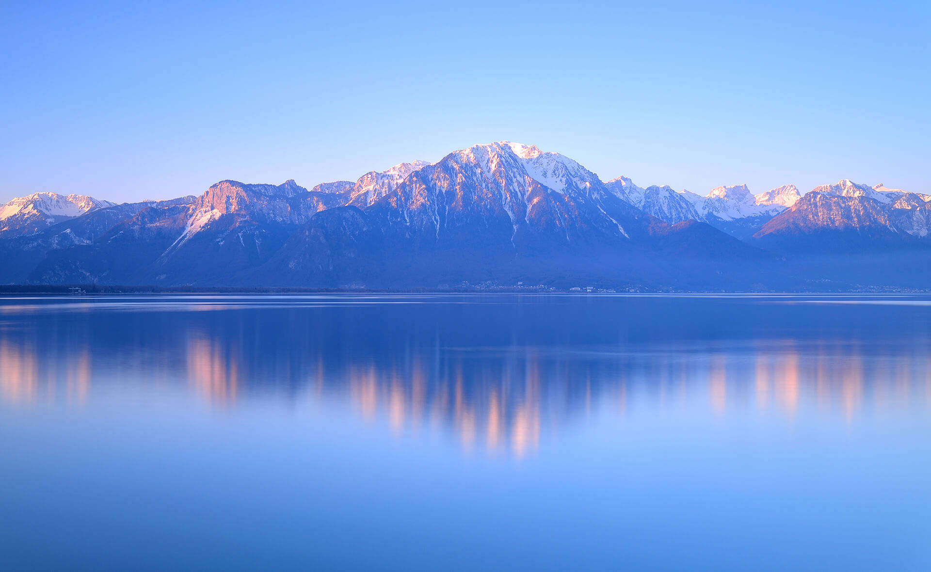 background image showing snow covered mountains behind a lake